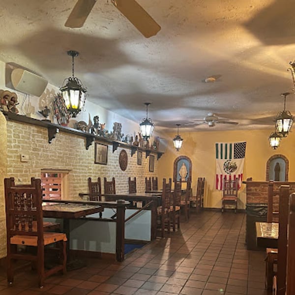 Interior of Sol Azteca, a Mexican restaurant, with wooden tables, chairs, and decorative lanterns.